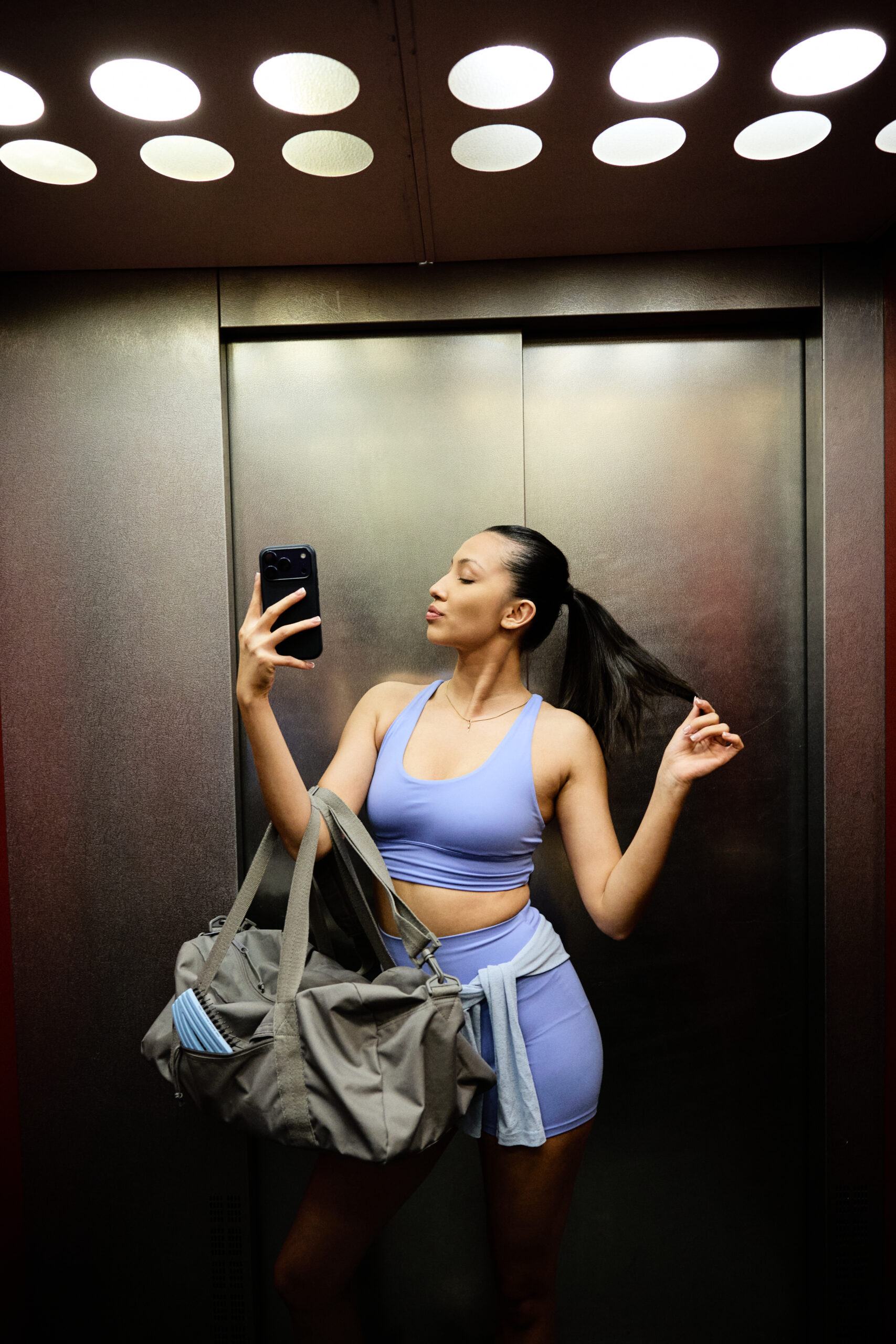 brown hair girl in an elevator in sport clothes