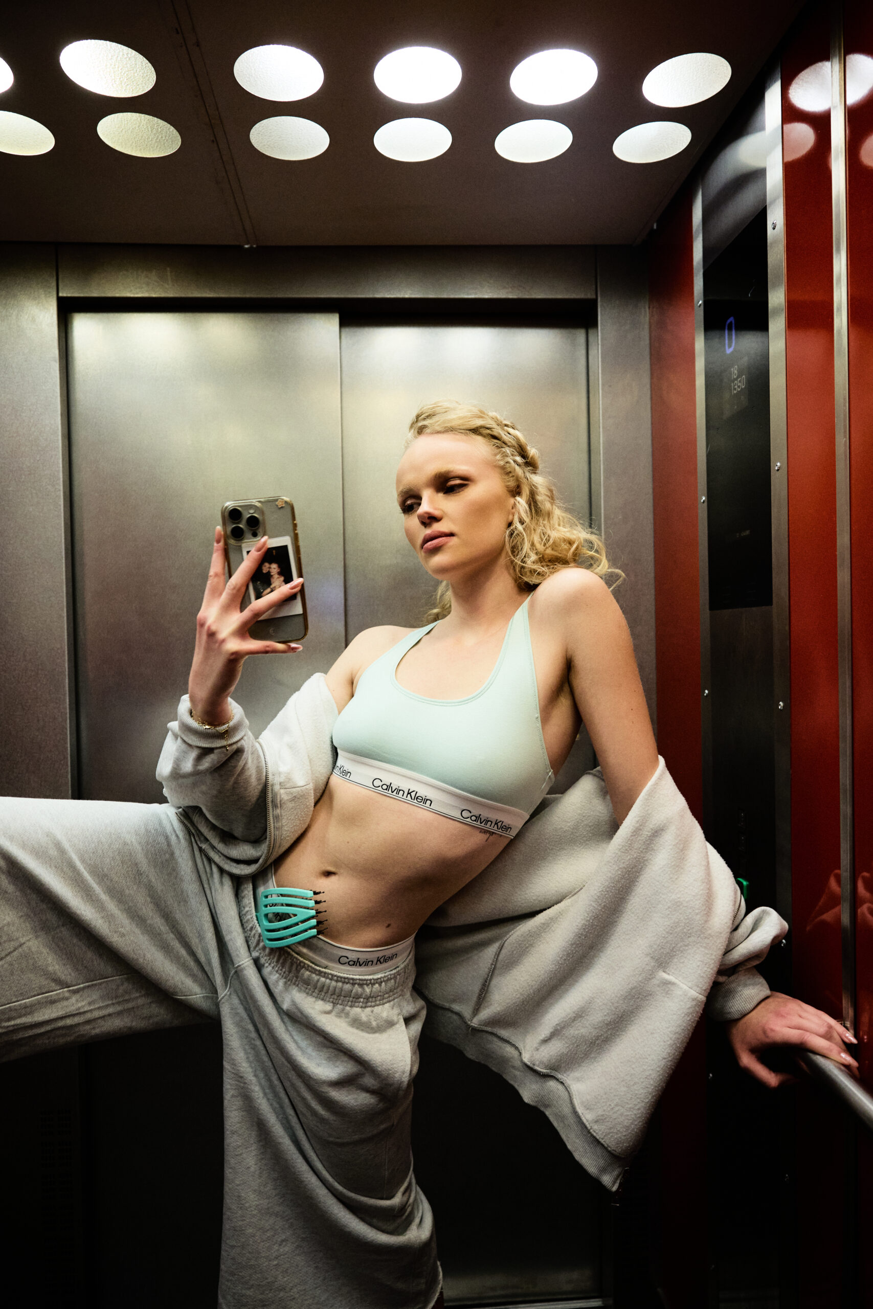 blond girl in an elevator wearing sport clothes